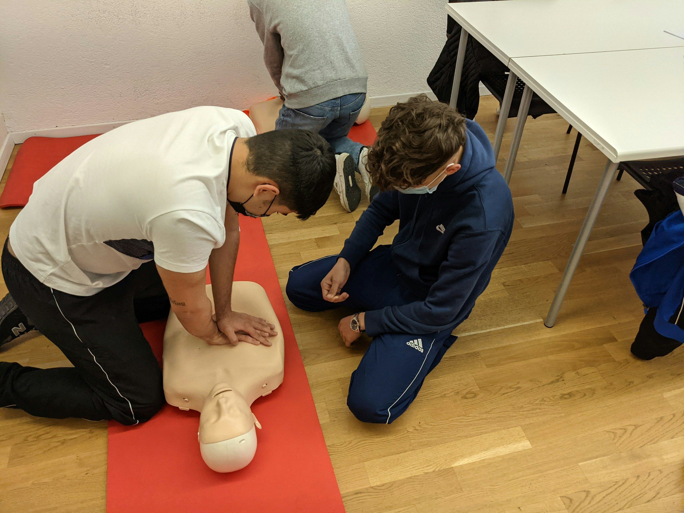 Deux personnes s'exercent au massage cardiaque sur un mannequin